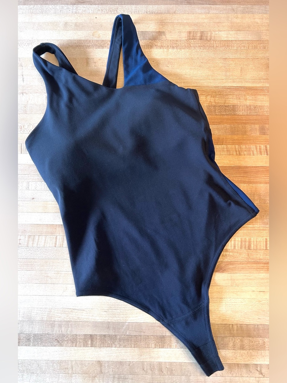 Lululemon Nulu Asymmetrical Bodysuit in the Black / True Navy colorway.